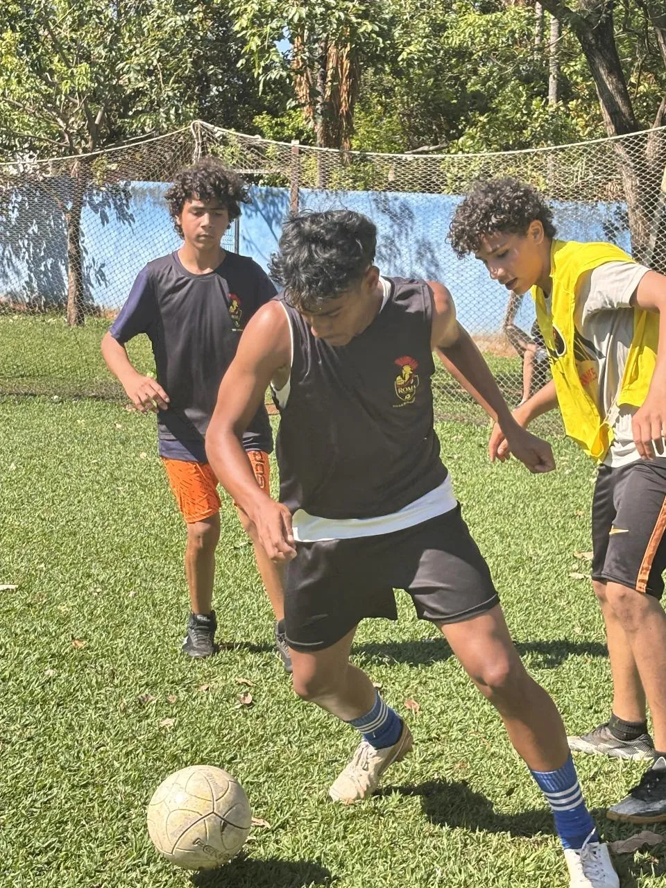 Jovens disputando a bola durante uma atividade do Projeto Roma
