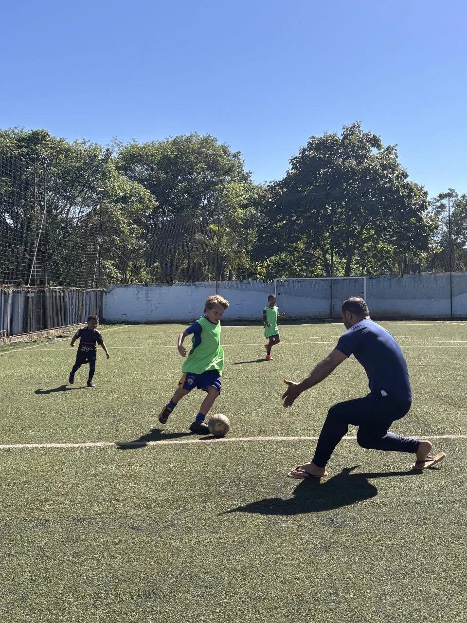 Criança conduzindo a bola durante uma jogada